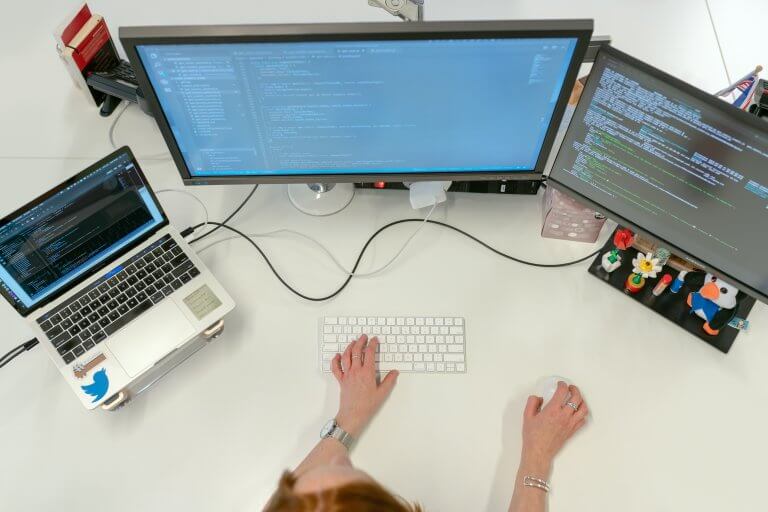une femme sur deux écrans qui font du code